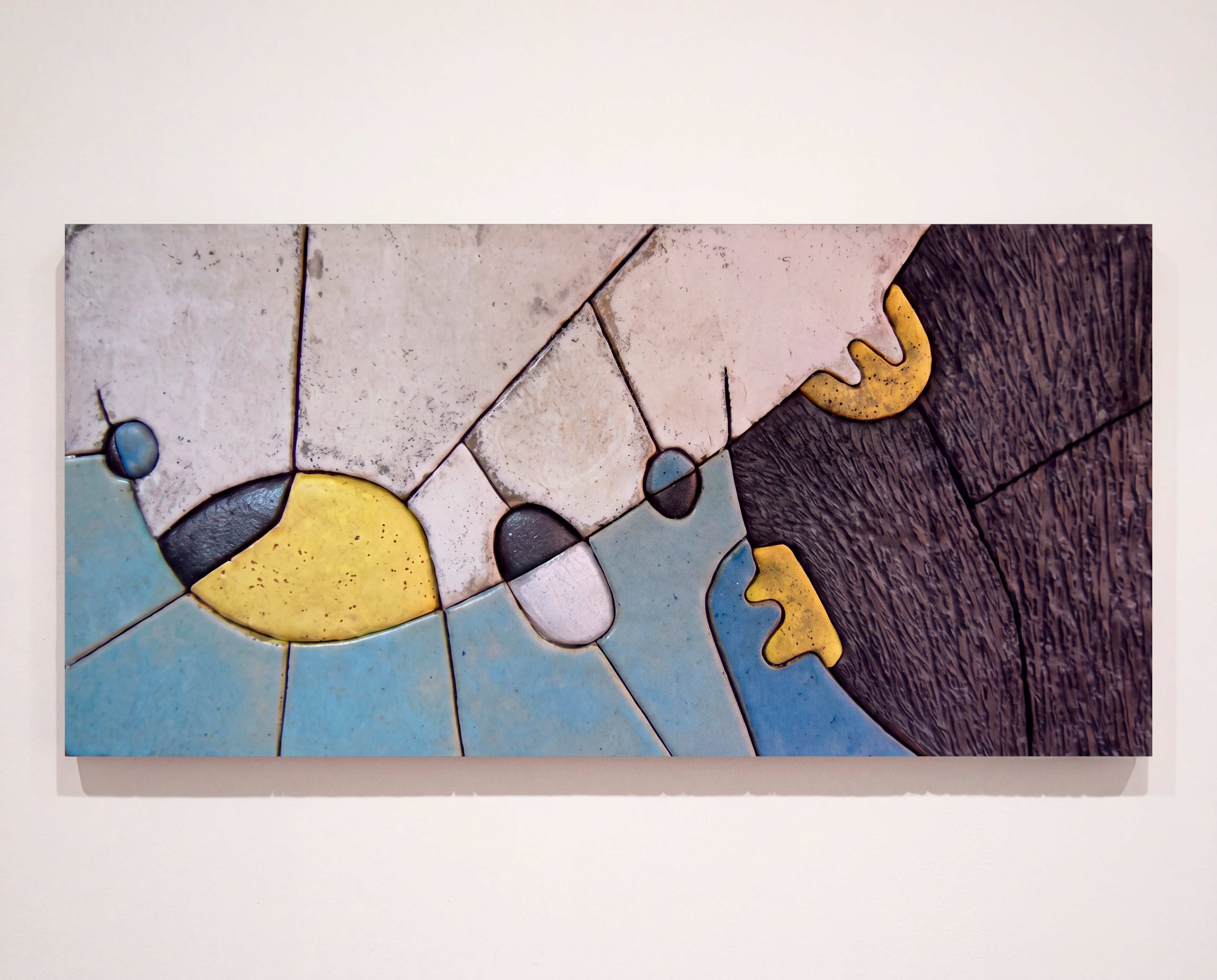 Detalle de mural cerámico con fragmentación, relieve y contraste matérico.