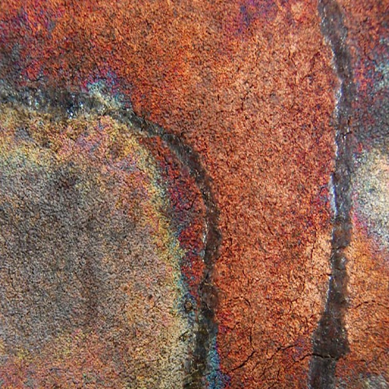 Detalle Raku donde el cobre, el humo y la reducción dejan reflejos sobre la superficie.